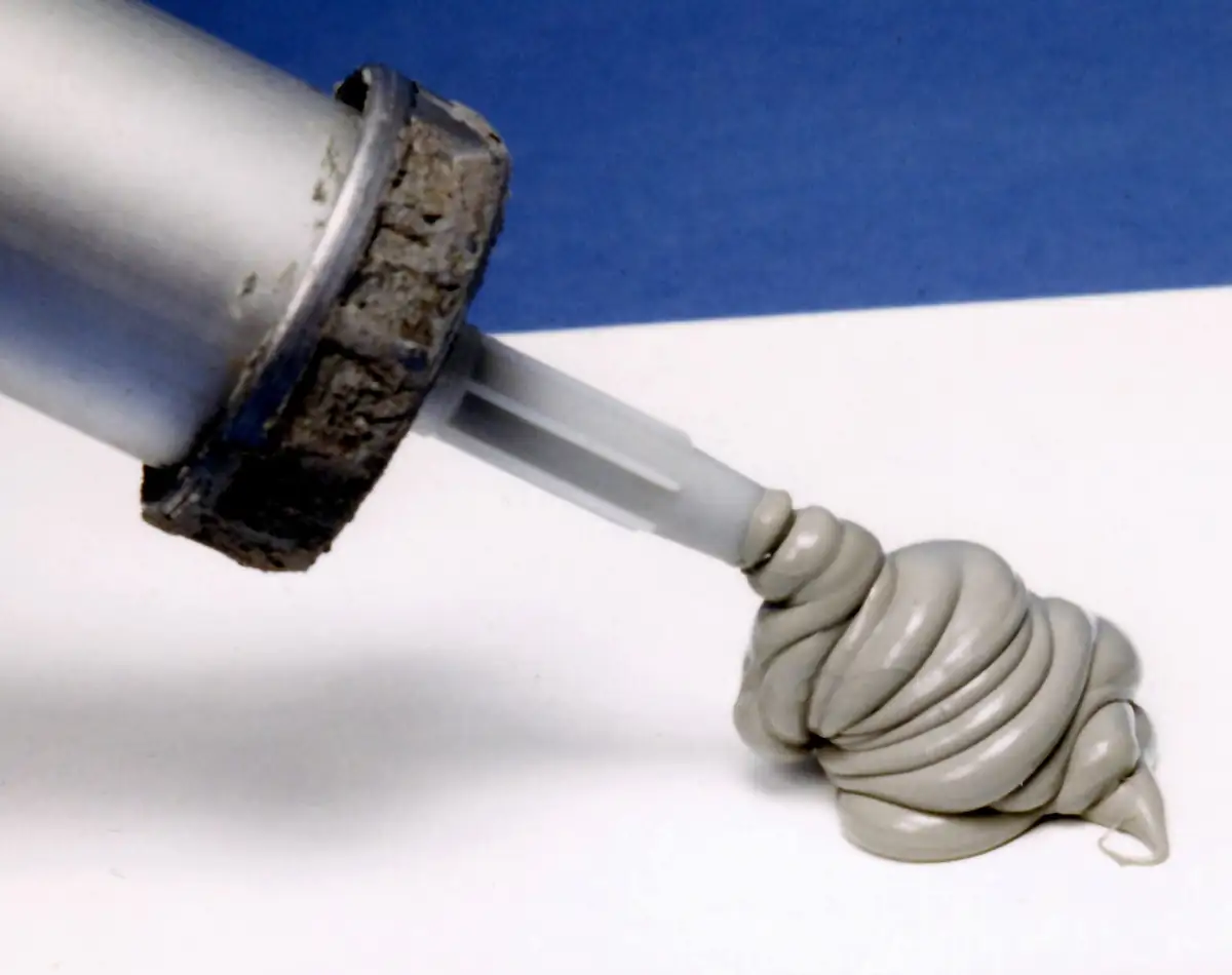 Caulk gun laying a bead of sealant for crack-sealing work