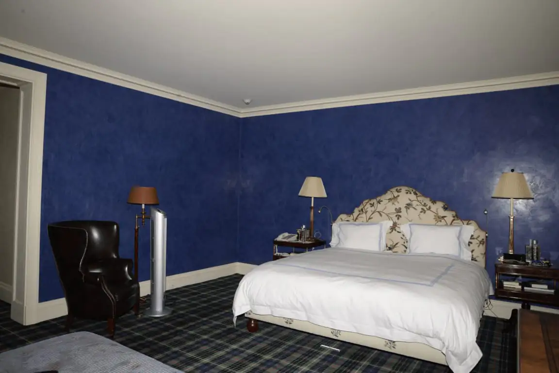 Hotel bedroom with made bed and nightstands, the classic per-room pricing unit