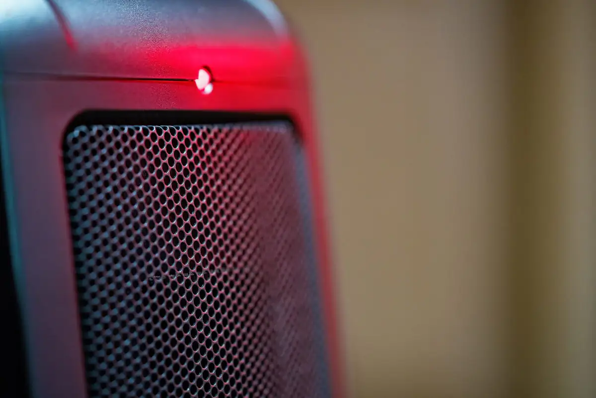 Glowing electric space heater close up in a dark room
